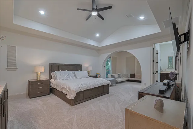 a spacious bedroom with a bed a couch and cabinet