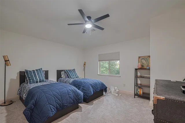 a spacious bedroom with two beds and a window