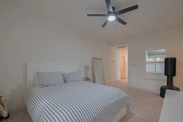 a bedroom with a bed and a flat tv screen on the dresser
