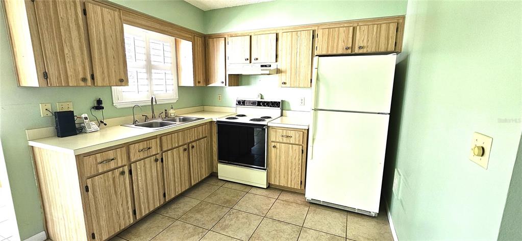 8274 Southwest 106th Place Ocala, FL 34481 - Photo 12 of 40 a kitchen with a sink a refrigerator and a window