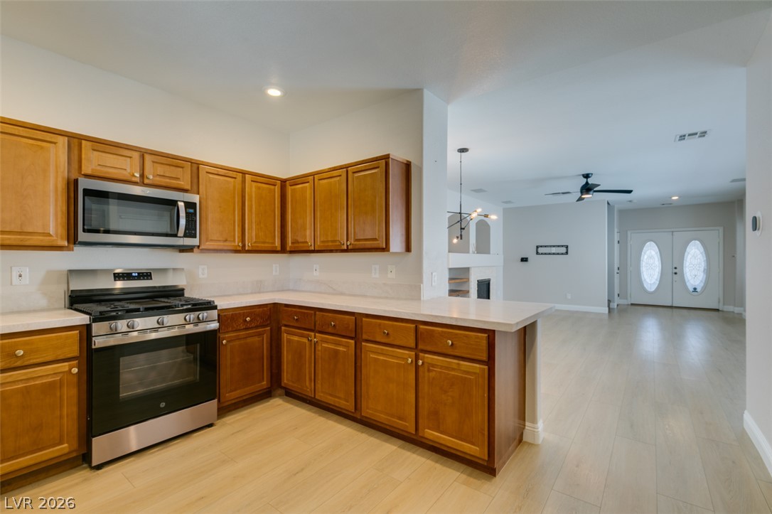 8909 Houston Ridge Avenue Las Vegas, NV 89178 - Photo 18 of 45 An inviting open-concept kitchen features warm cabinetry and modern stainless steel appliances.