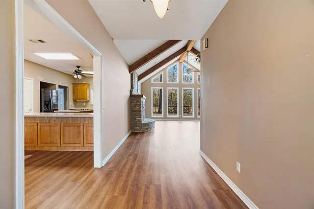 a view of a hallway with wooden floor and staircase