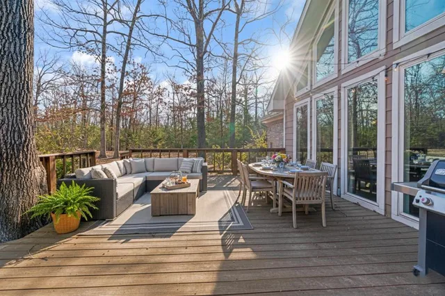 a view of a patio with dining table and chairs with wooden floor and fence