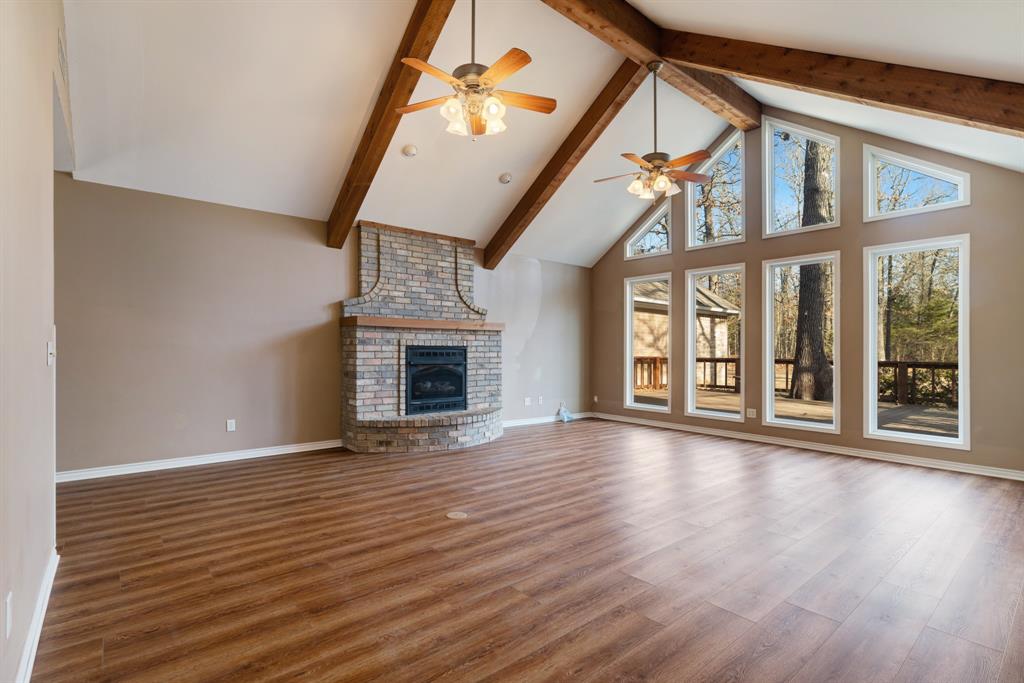126 Hidden Lake Drive Powderly, TX 75473 - Photo 3 of 29 an empty room with wooden floor fireplace and windows