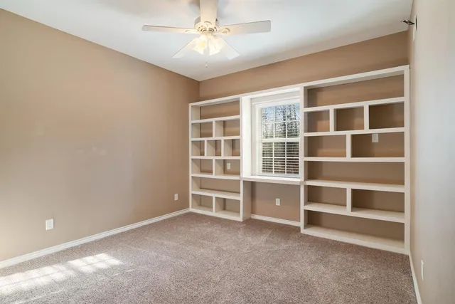 a view of an empty room with a window and cabinet