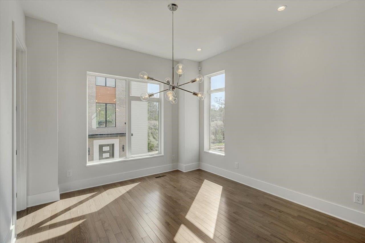 749 Willard Street, Unit 7 Durham, NC 27701 - Photo 13 of 43 a view of an empty room with a window and wooden floor