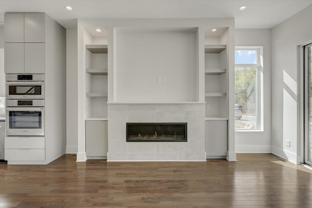 749 Willard Street, Unit 7 Durham, NC 27701 - Photo 4 of 43 an empty room with wooden floor a fireplace and windows