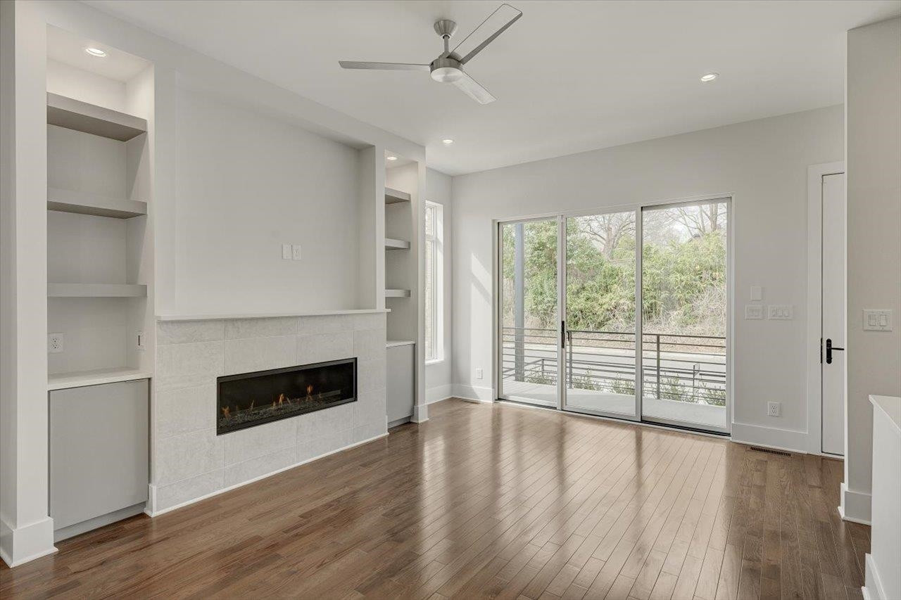 749 Willard Street, Unit 7 Durham, NC 27701 - Photo 5 of 43 an empty room with wooden floor fireplace and windows
