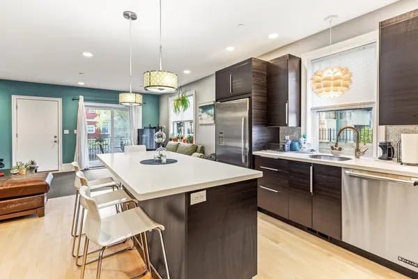a kitchen with stainless steel appliances kitchen island granite countertop a sink a stove and a refrigerator