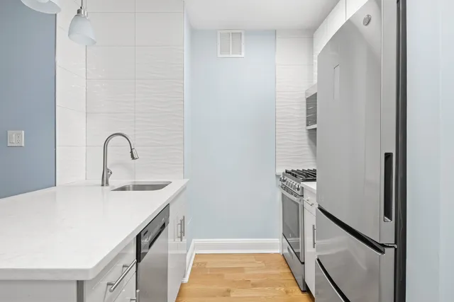 a kitchen with stainless steel appliances granite countertop a refrigerator and a sink