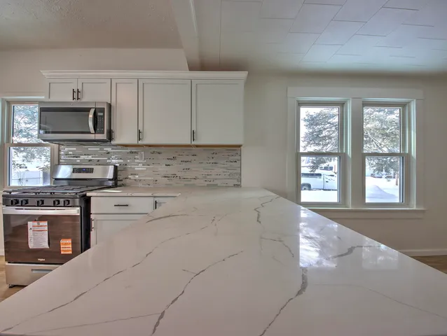 a kitchen with stainless steel appliances a stove sink and microwave