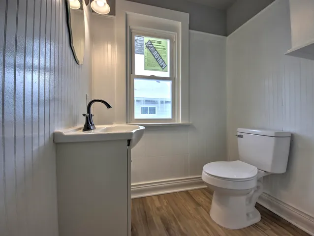 a bathroom with a toilet sink and mirror