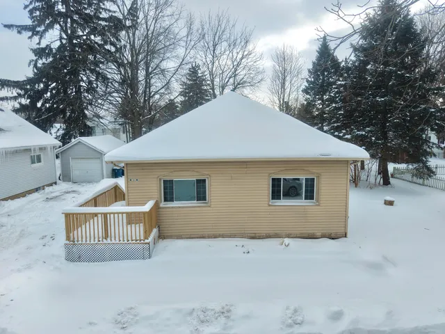 a front view of house with yard and trees around