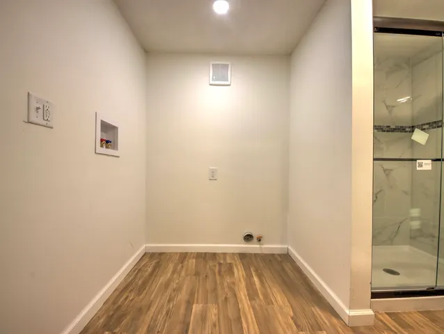 a view of a room with wooden floor and brick walls