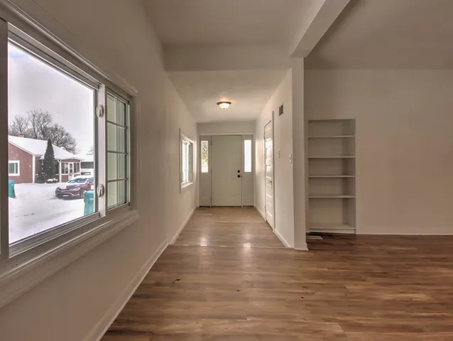 a view of entryway with wooden floor and windows