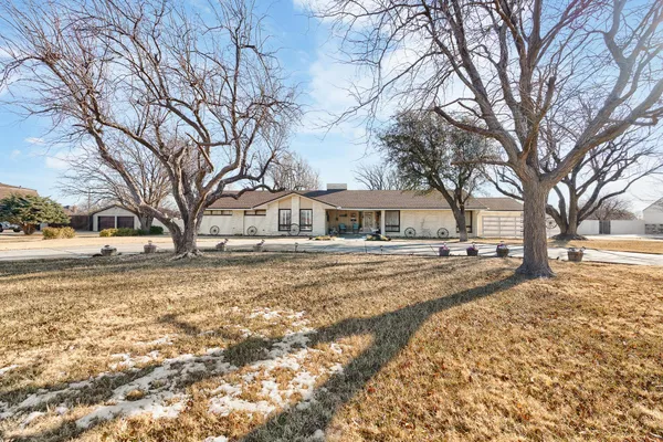 a front view of a house with a yard covered in snow