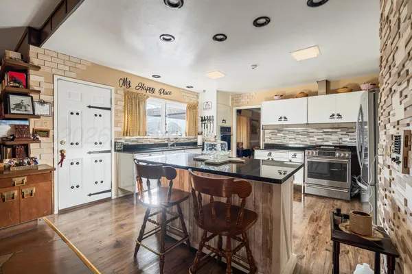 a kitchen with kitchen island a stove a table and chairs in it