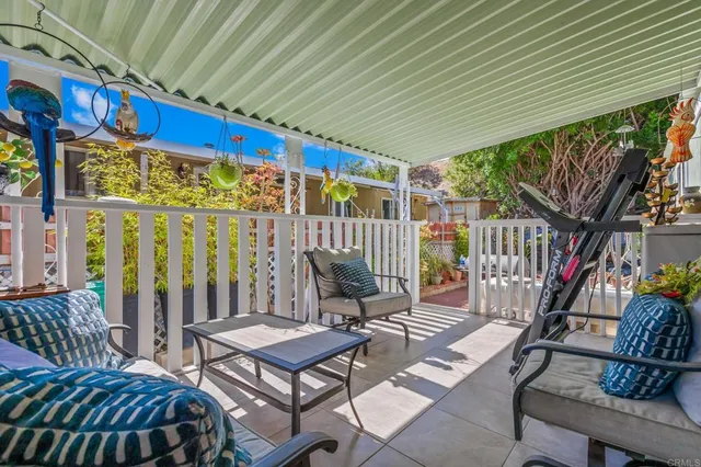 a view of a patio with table and chairs with wooden floor and fence