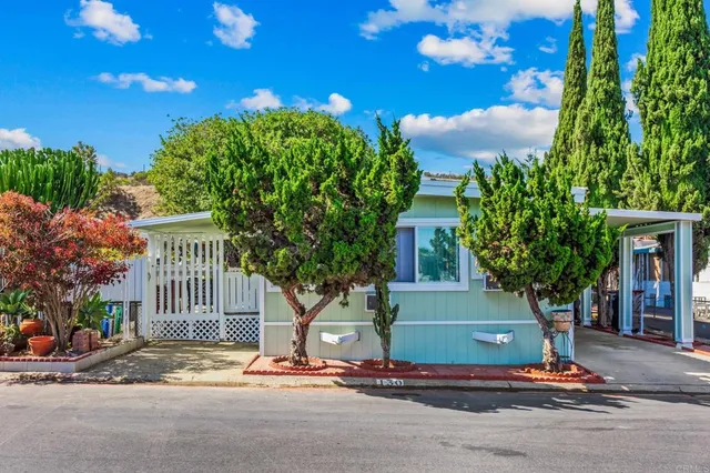 a front view of a house with a tree