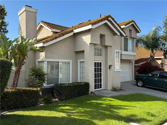 a view of a white house with a big yard and potted plants