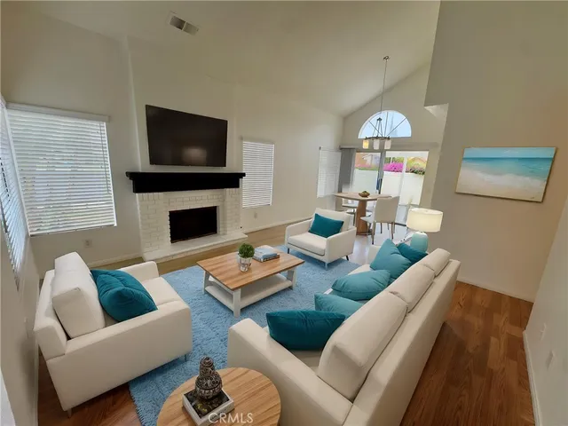 a living room with furniture a flat screen tv and a fireplace