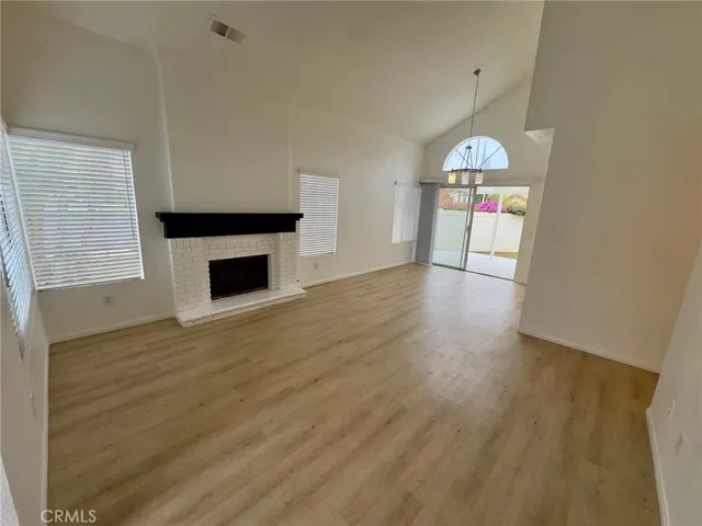 an empty room with wooden floor and fireplace