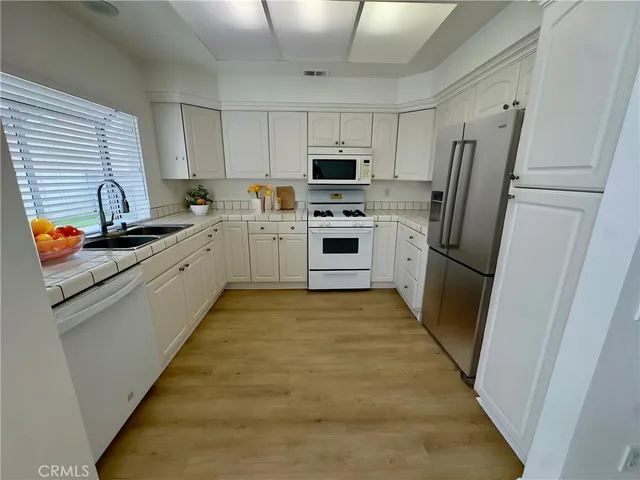 a kitchen with stainless steel appliances a refrigerator sink and microwave