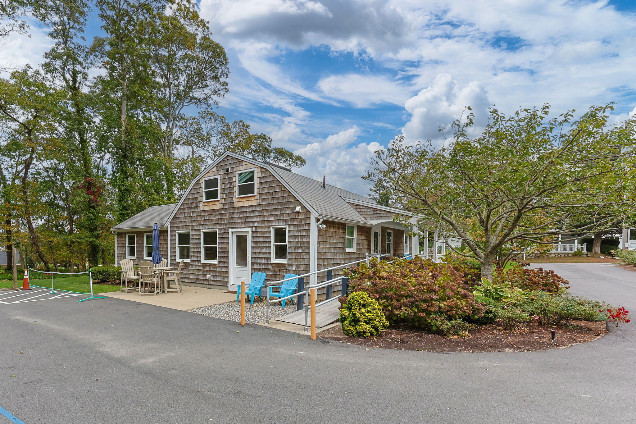 29 West Road Orleans, MA 02653 - Photo 9 of 27 a front view of a house with a garden and trees