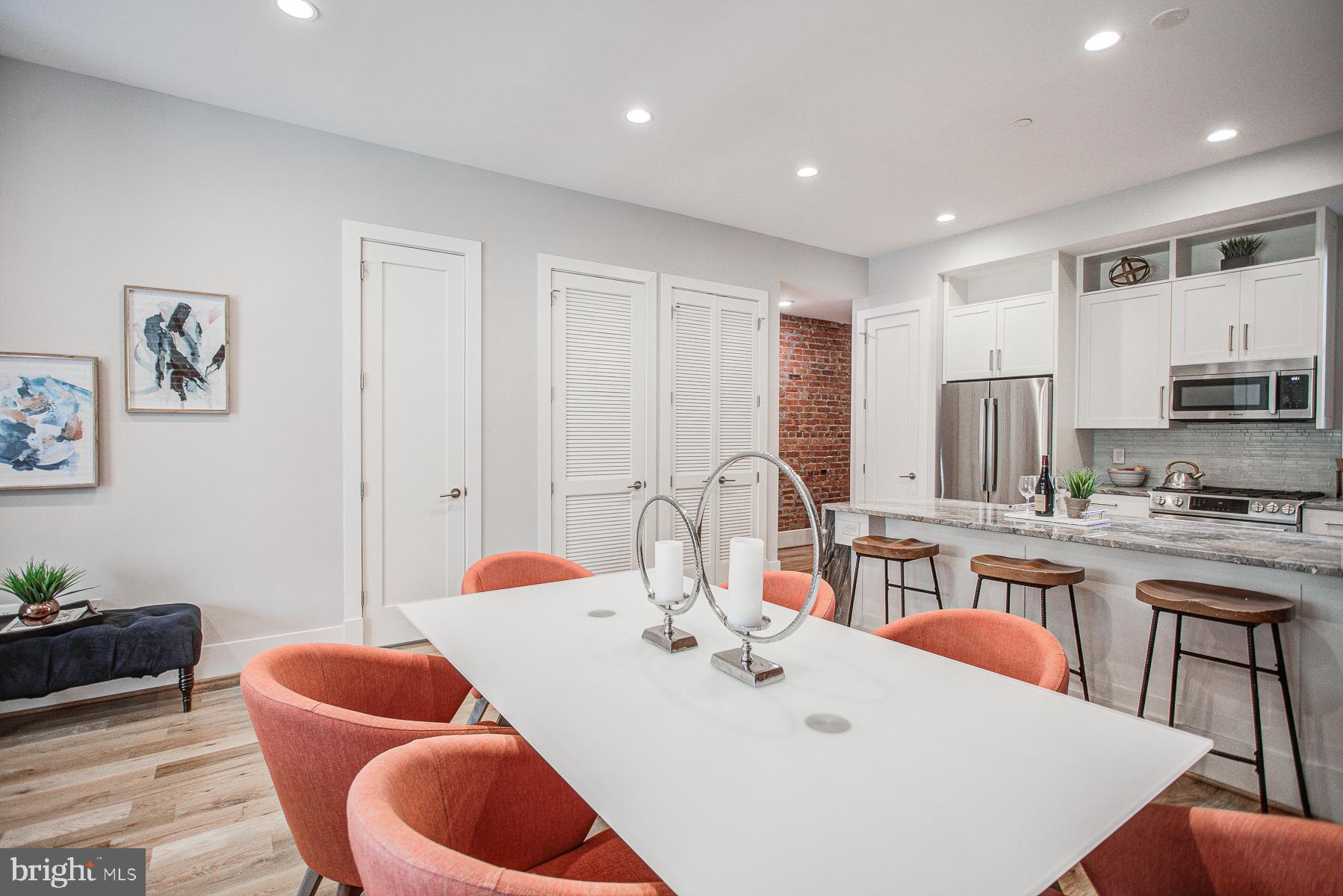 2024 16th Street Northwest, Unit C Washington, DC 20009 - Photo 11 of 27 a kitchen with stainless steel appliances granite countertop a dining table chairs and white cabinets