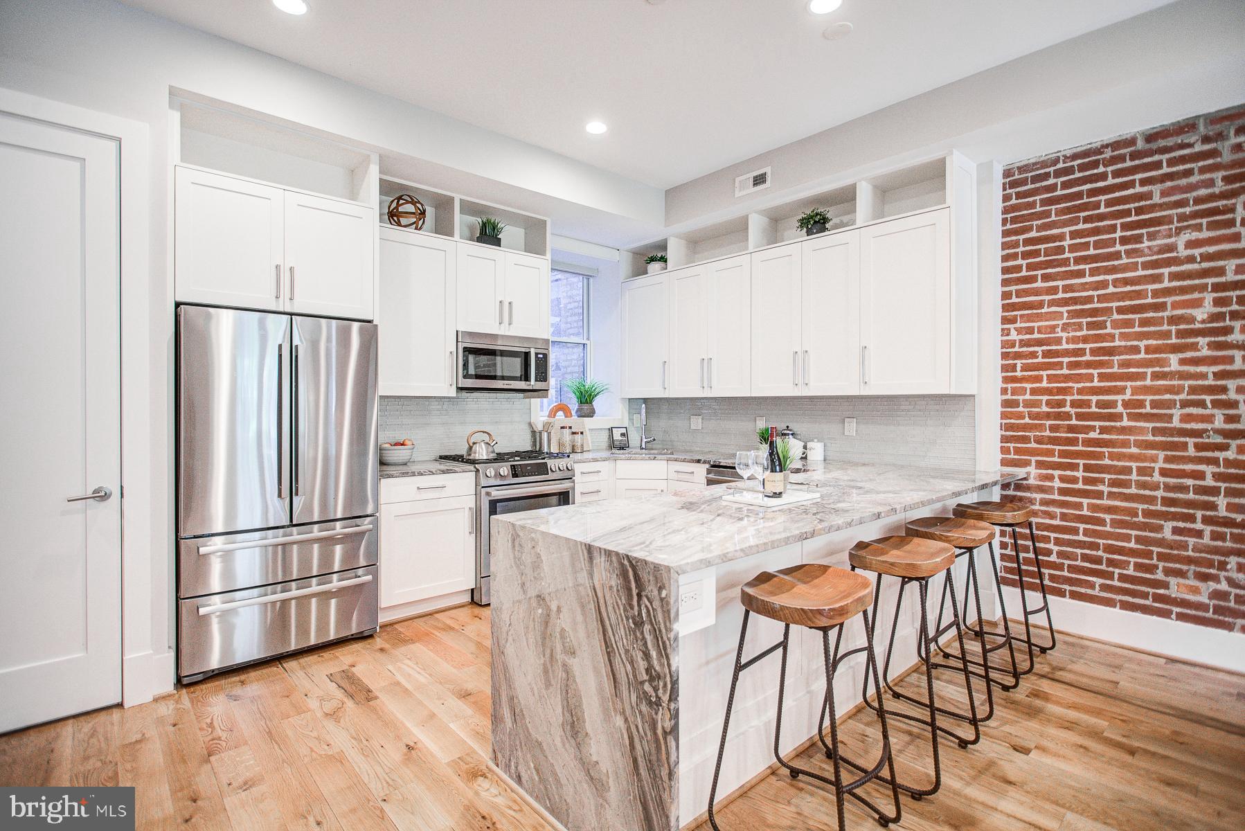 2024 16th Street Northwest, Unit C Washington, DC 20009 - Photo 13 of 27 a kitchen with stainless steel appliances granite countertop a refrigerator a stove a sink a dining table and chairs