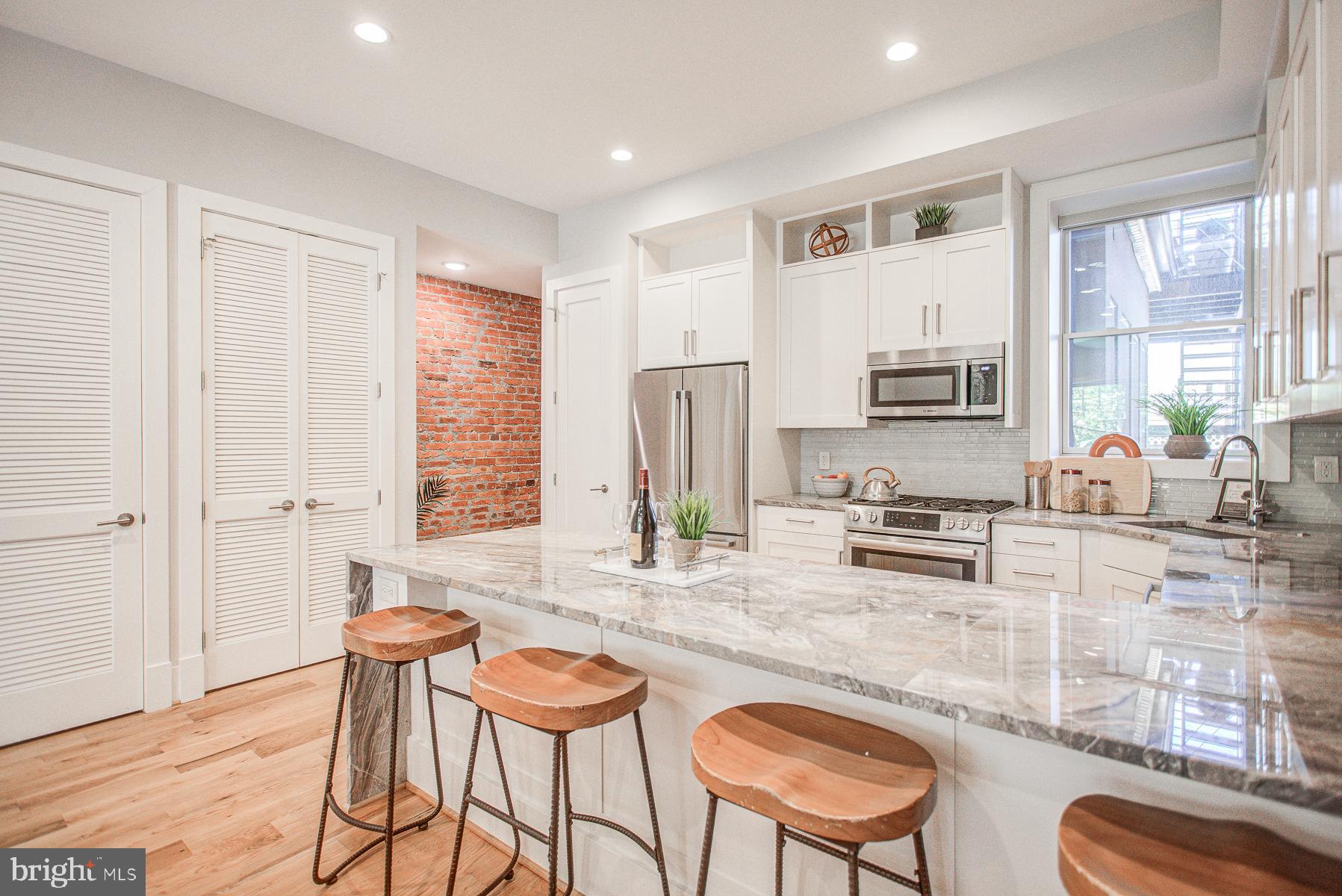2024 16th Street Northwest, Unit C Washington, DC 20009 - Photo 14 of 27 a kitchen with stainless steel appliances granite countertop a stove a sink a refrigerator dining table and chairs