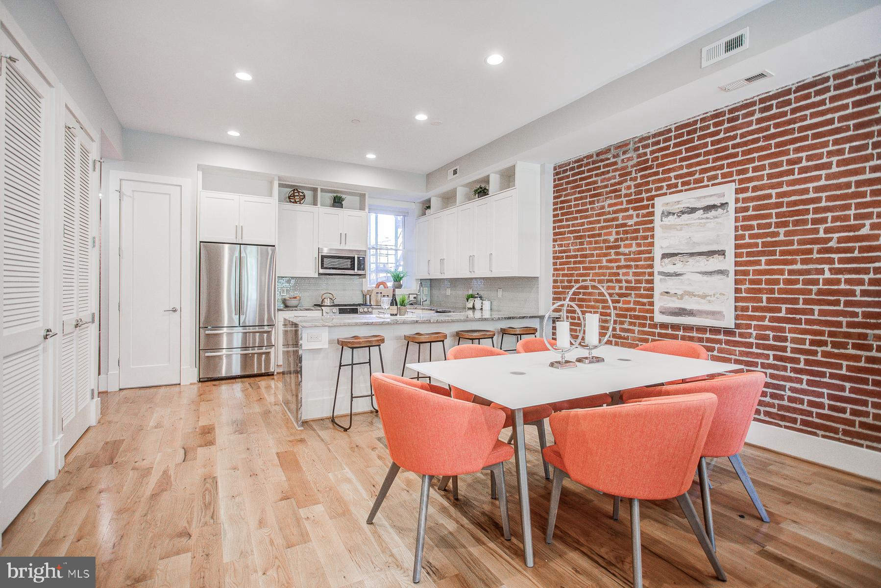 2024 16th Street Northwest, Unit C Washington, DC 20009 - Photo 9 of 27 a kitchen with stainless steel appliances kitchen island granite countertop a dining table chairs and white cabinets