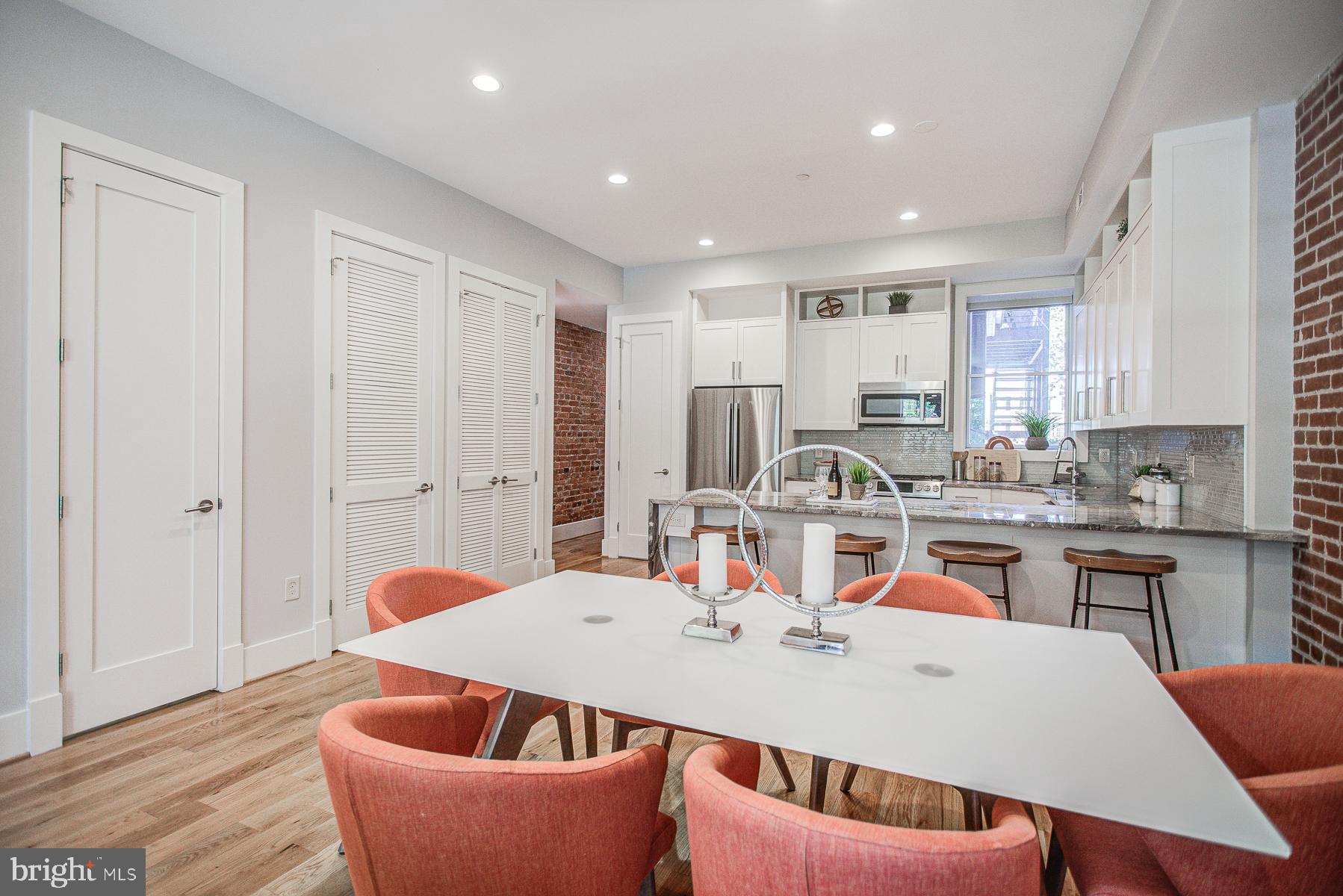 2024 16th Street Northwest, Unit C Washington, DC 20009 - Photo 10 of 27 a large kitchen with kitchen island a stove a sink a dining table and chairs