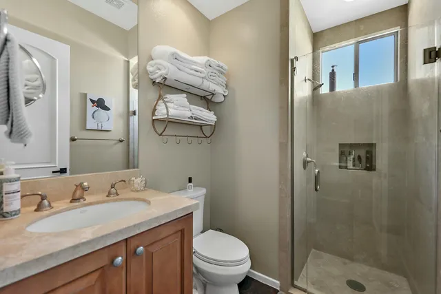 a bathroom with a granite countertop sink toilet and shower