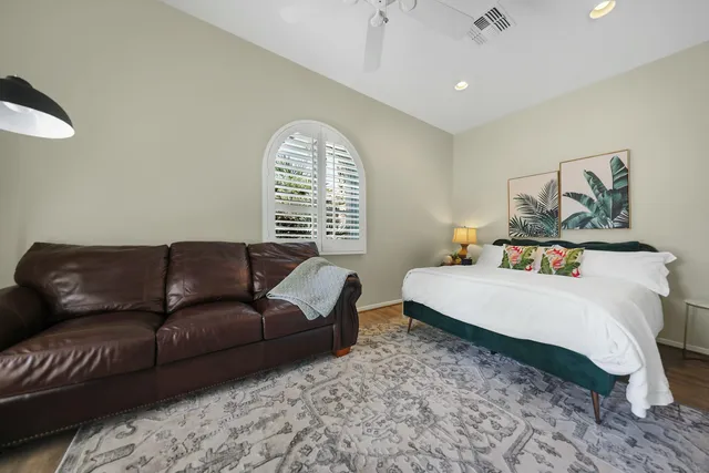 a spacious bedroom with a bed a couch and a window