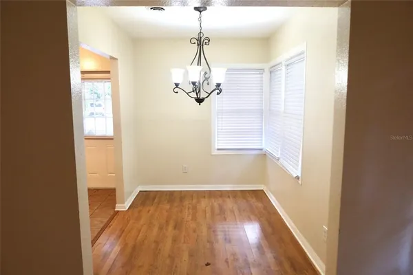 a view of a room with wooden floor and windows