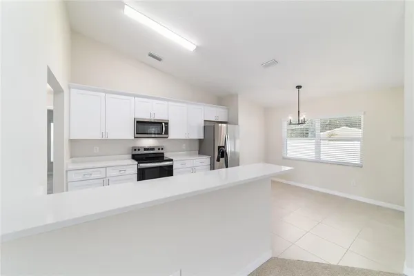 a view of a kitchen with furniture and stainless steel appliances