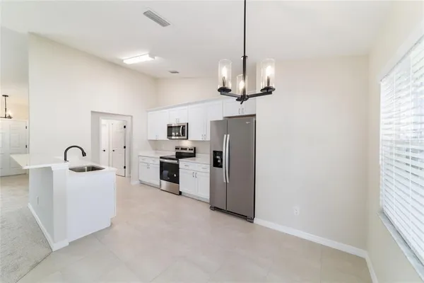 a kitchen with a sink white cabinets and white appliances