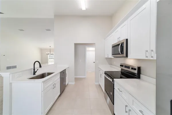 a kitchen with granite countertop a sink cabinets and stainless steel appliances