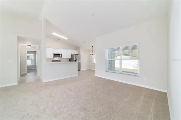 a large white kitchen with kitchen island a sink a center island a stove and a window