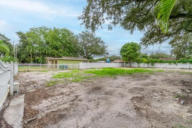 a front view of a house with a yard and green space