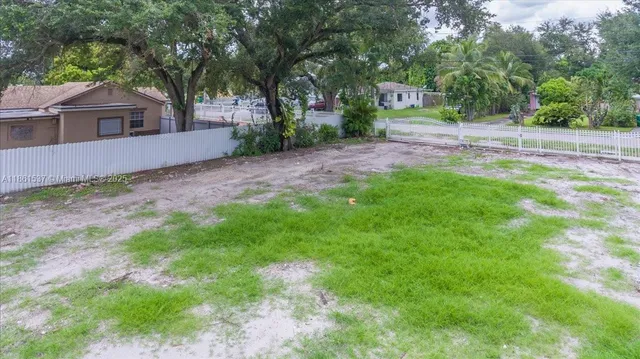 a view of a yard with plants and trees