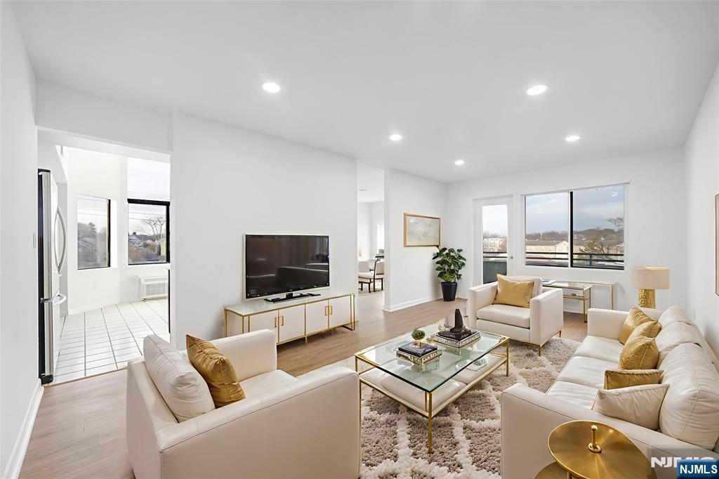 850 Main Street, Unit 306 Hackensack, NJ 07601 - Photo 2 of 8 a living room with furniture a rug and a flat screen tv