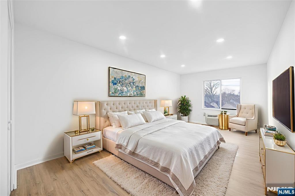 850 Main Street, Unit 306 Hackensack, NJ 07601 - Photo 5 of 8 a bedroom with a bed and wooden floor