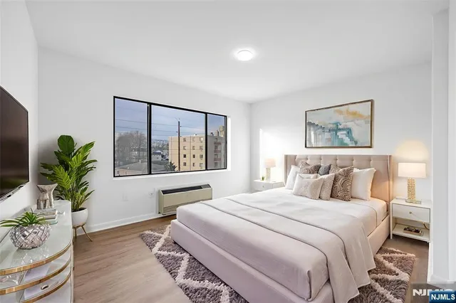 a bedroom with a large bed and a potted plant