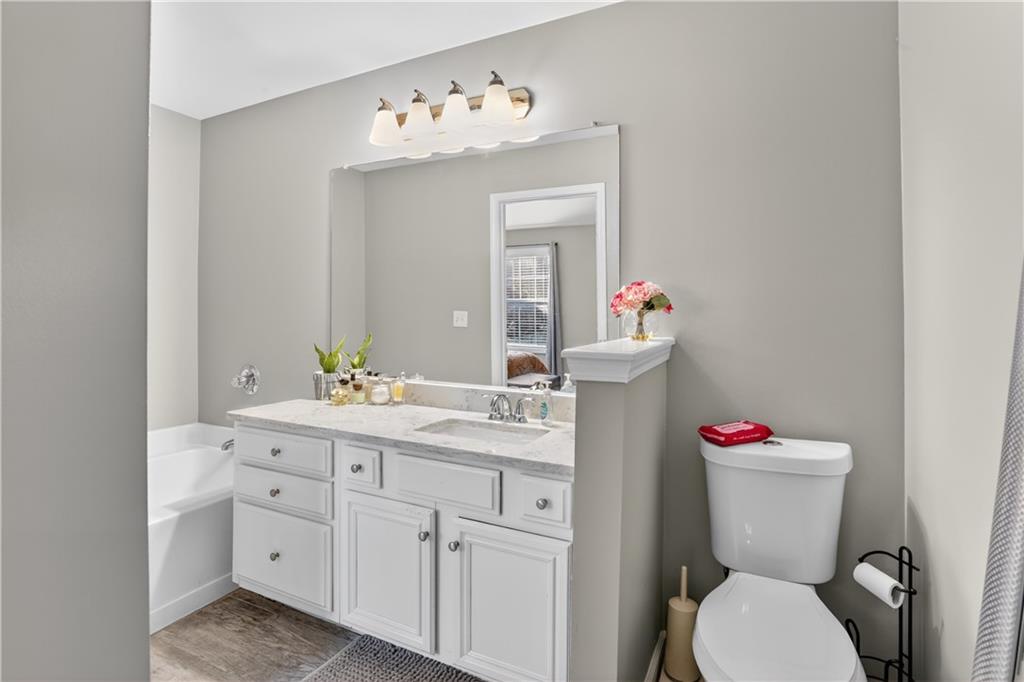 2555 Flat Shoals Road, Unit 1304 Atlanta, GA 30349 - Photo 17 of 27 a bathroom with a toilet sink and mirror