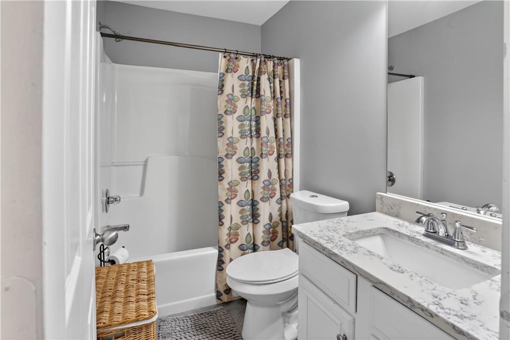 2555 Flat Shoals Road, Unit 1304 Atlanta, GA 30349 - Photo 22 of 27 a bathroom with a granite countertop sink toilet and shower