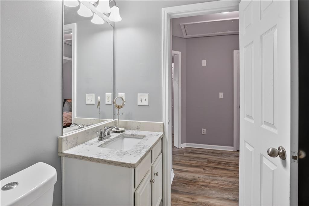 2555 Flat Shoals Road, Unit 1304 Atlanta, GA 30349 - Photo 23 of 27 a bathroom with a granite countertop sink a large mirror and a shower
