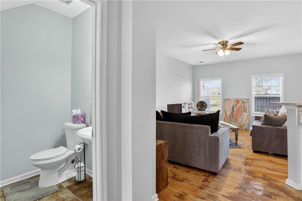2555 Flat Shoals Road, Unit 1304 Atlanta, GA 30349 - Photo 3 of 27 a living room with furniture a chandelier and a toilet