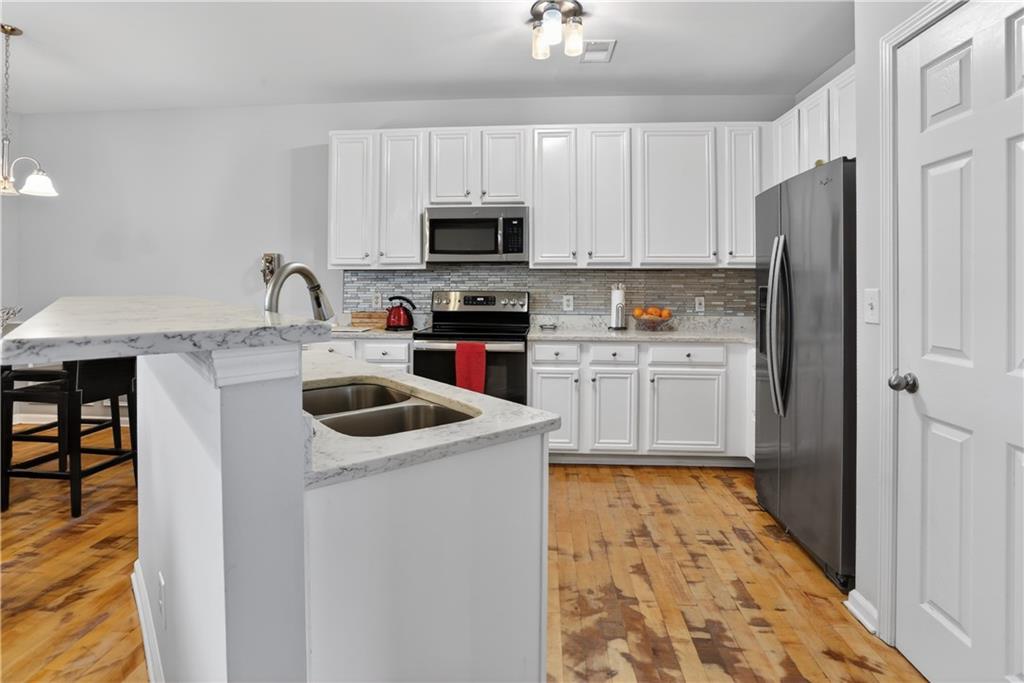 2555 Flat Shoals Road, Unit 1304 Atlanta, GA 30349 - Photo 5 of 27 a kitchen with stainless steel appliances granite countertop a sink stove and refrigerator
